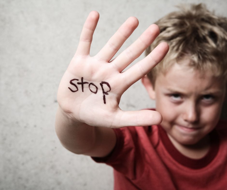 Ein Junge mit erhobener Hand auf der Innenseite der Hand steht STOP.